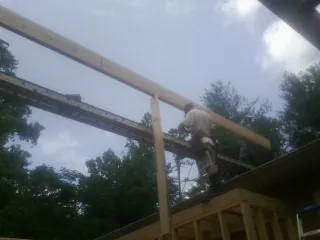 Carpenter setting a ridge beam over a new addition frame — Ice Dam Removal by Roofing Brothers in Coldspring