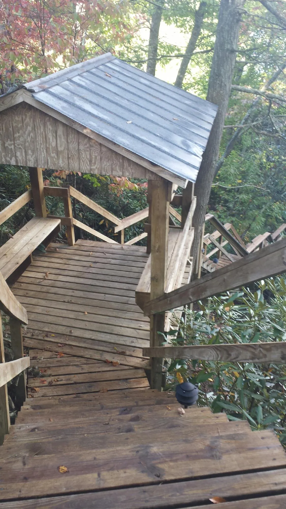 Metal roofed shelter over wooden steps on a wooded walkway — Skylight Repair & Installation work by our crew in Coldspring