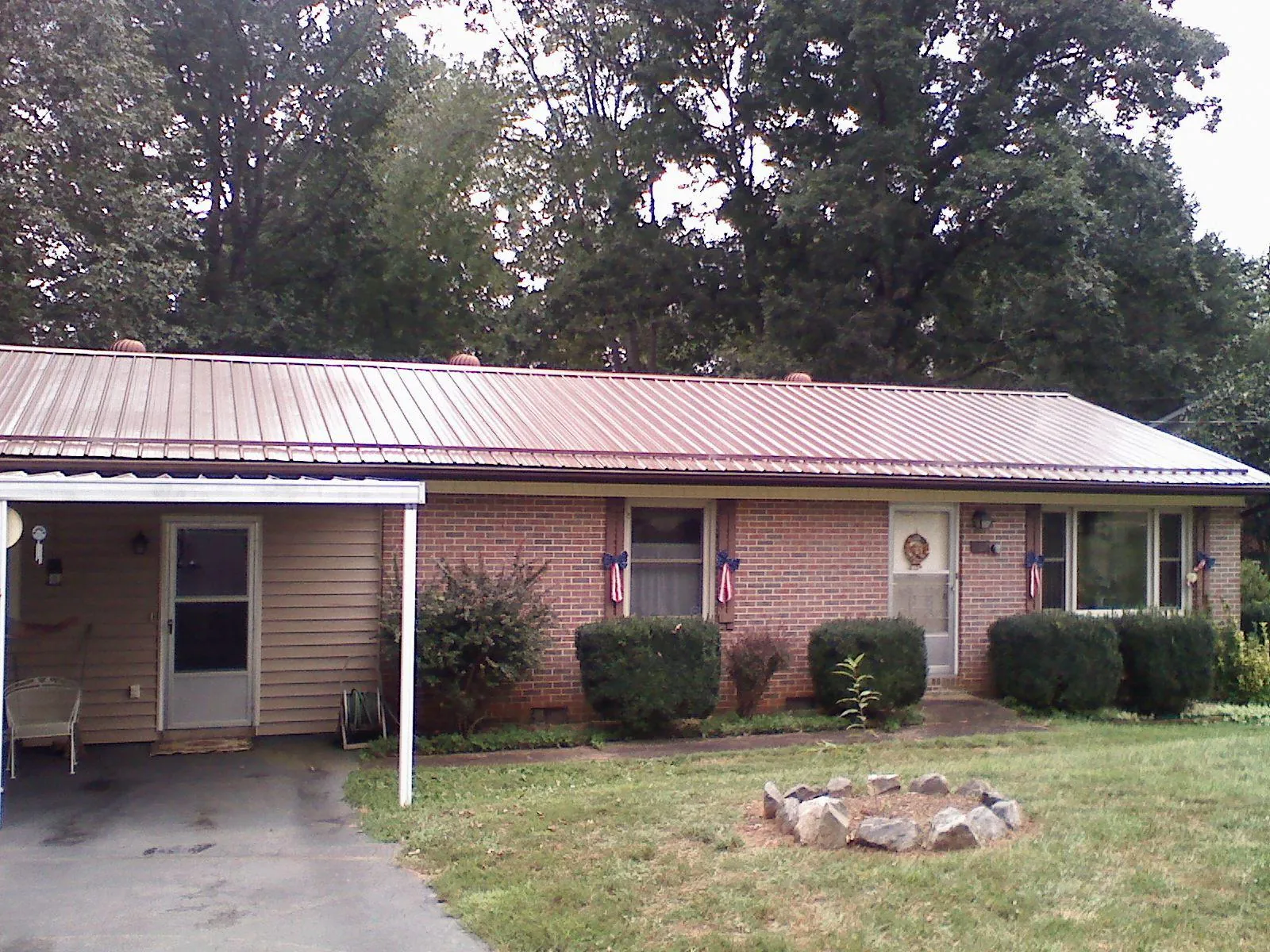 Bronze metal roof and carport on a brick ranch home — Roof Repair work by our crew in Coldspring